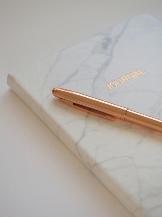 cahier avec un stulo doré