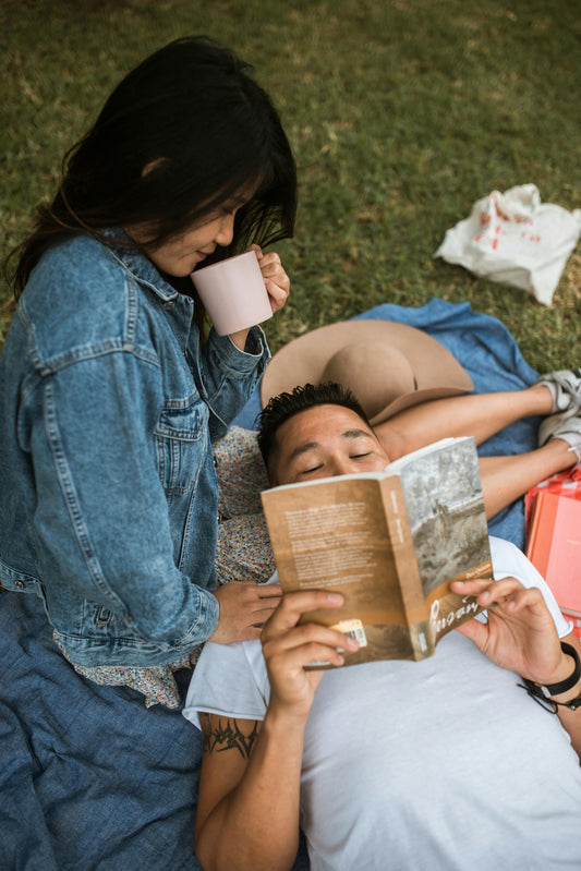 homme qui lit une histoire a une fille allonge sur l'herbe