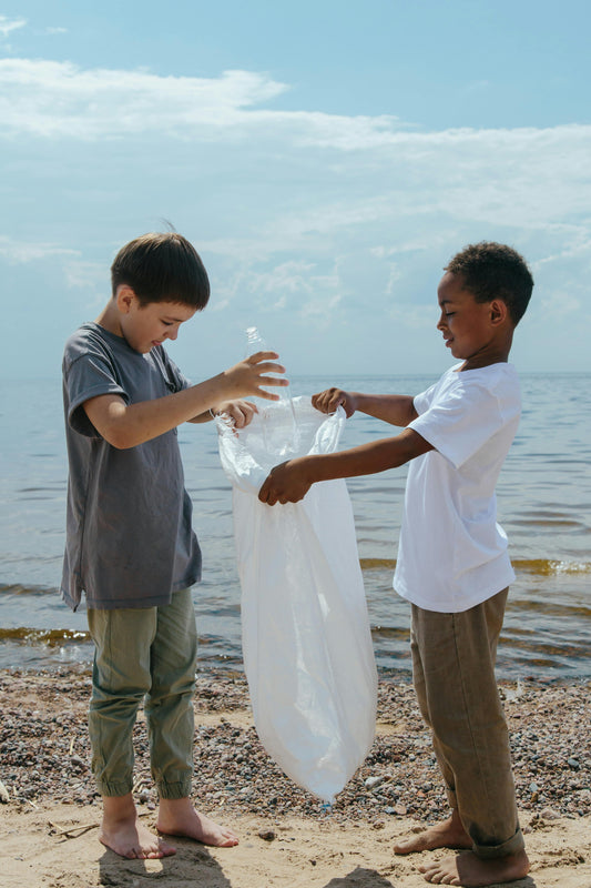 deux enfants ramassent les déchets sur la plage