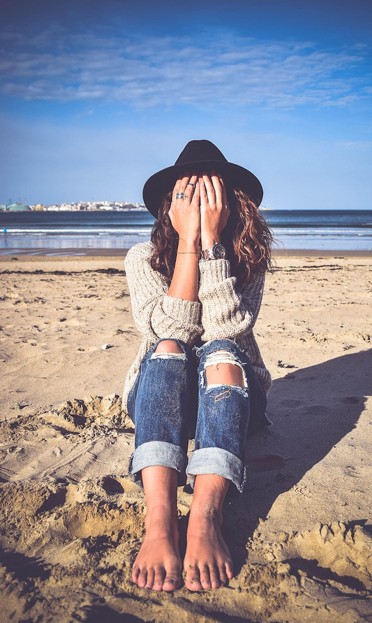 femme sur la plage qui cache son visage