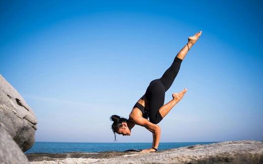 femme qui fait du yoga en haut d'une montagne
