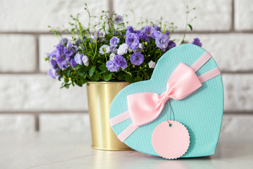 paquet cadeau bleu en forme de coeur avec ruban rose