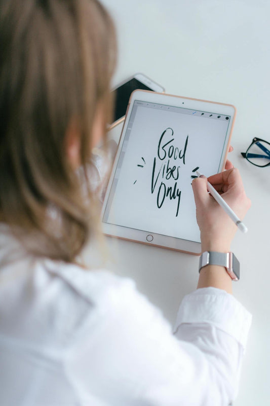 femme qui écrit good vibes only sur sa tabelette