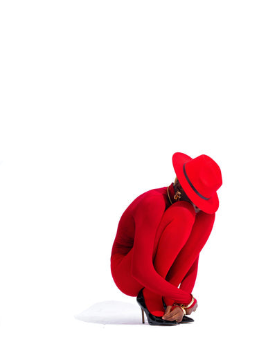 femme habiller en rouge agenouillée avec un chapeau