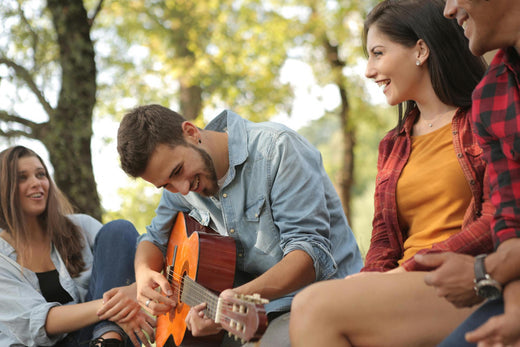 amis qui rigolent, l'un joue á la guitare 