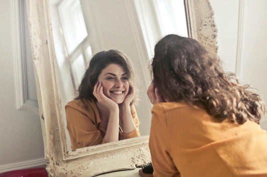 Femme qui se regarde devant le miroir et qui sourit