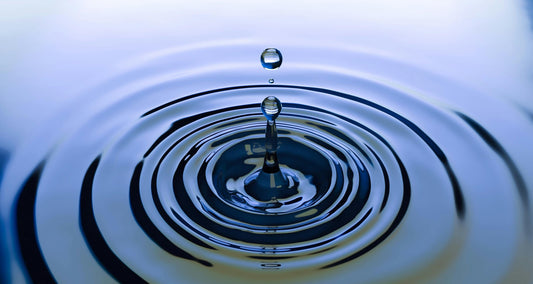 goutte d'eau qui vient tomber dans une flaque d'eau
