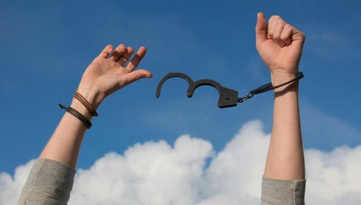 des mains qui ouvrent des menottes face au ciel