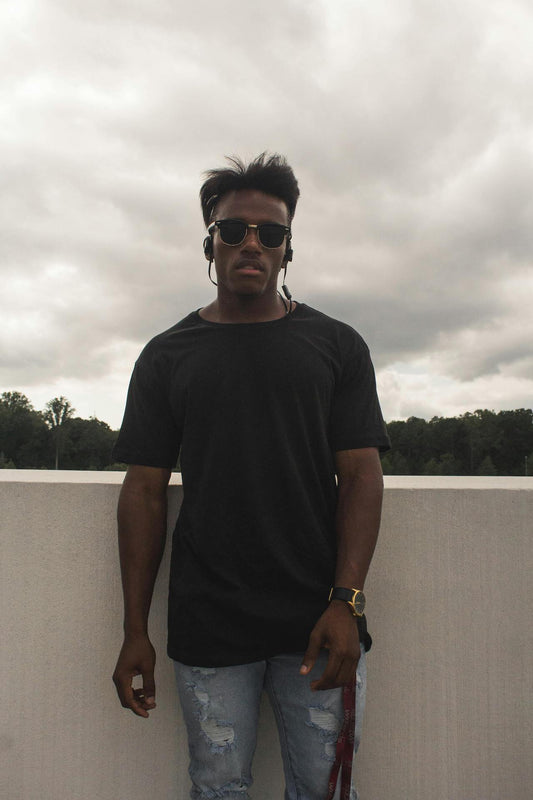 homme avec lunette t shirt et jean qui regarde l'objectif